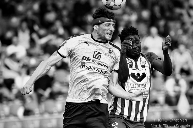 soccer-player-winning-heading-duel-wearing-protective-headband-bw-photo-by-ernst-van-norde-737×491.png